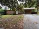 Ranch home featuring a covered carport, front yard with mature trees and a long driveway at 1932 Pharrs Rd, Snellville, GA 30078