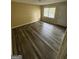 Sun-filled living room with wood flooring and white trim, a large window, and a white door at 1932 Pharrs Rd, Snellville, GA 30078