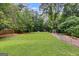 Expansive backyard with lush green lawn, surrounded by mature trees, perfect for outdoor activities at 90 Thomas Overby Dr, Sharpsburg, GA 30277