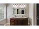 Bathroom featuring a double vanity, marble countertops, decorative mirror, and dark wood cabinets at 90 Thomas Overby Dr, Sharpsburg, GA 30277