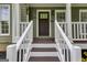 Inviting front porch with white railings and a stylish front door that has beautiful trim at 90 Thomas Overby Dr, Sharpsburg, GA 30277