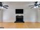 Bright living room featuring a stone fireplace, hardwood floors, and ceiling fans at 90 Thomas Overby Dr, Sharpsburg, GA 30277