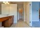 Neutral bathroom with a wood vanity, large mirror, and entrance to the hall at 275 Autry Mill Ln, Suwanee, GA 30024