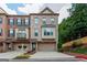 Charming brick townhome featuring a two-car garage, multiple windows, and well-manicured landscaping at 275 Autry Mill Ln, Suwanee, GA 30024