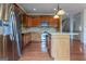 Bright kitchen with hardwood floors, stainless steel refrigerator, kitchen island, and natural wood cabinetry at 275 Autry Mill Ln, Suwanee, GA 30024