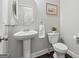 Elegant half bathroom features a pedestal sink, a round mirror, and modern fixtures at 733 Wexford Cove Way, Mableton, GA 30126