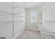 Spacious walk-in closet featuring white wire shelving and a window with neighborhood views at 733 Wexford Cove Way, Mableton, GA 30126