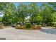 Gated community entrance featuring stone accents, mature trees, and colorful flowerbeds at 733 Wexford Cove Way, Mableton, GA 30126