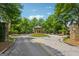 Scenic entrance with stone pillars, roundabout, gazebo, and lush landscaping under a blue sky at 733 Wexford Cove Way, Mableton, GA 30126
