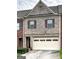 Townhouse boasts an attached garage and complementary brickwork providing a distinctive street presence at 7177 Fringe Flower Dr, Austell, GA 30168