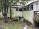 Outside of home with overgrown foliage and weathered facade near old windows at 11591 Turner Rd, Hampton, GA 30228