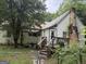 Exterior front of property featuring a small porch, overgrown foliage, and a chimney at 11591 Turner Rd, Hampton, GA 30228