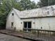 Rear exterior of property with large deck, slide door, and interesting yard art at 11591 Turner Rd, Hampton, GA 30228