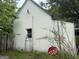 Side exterior of house featuring window, overgrowth, and a stop sign on the ground at 11591 Turner Rd, Hampton, GA 30228