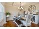 Stylish dining area with a modern chandelier, comfortable seating, and views into adjacent rooms at 117 Elkins Blvd, Locust Grove, GA 30248