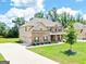 Home featuring a long driveway leading to an attached garage, beautiful landscaping, and a spacious lawn at 117 Elkins Blvd, Locust Grove, GA 30248