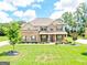 Inviting two-story home boasts a manicured lawn and a mix of brick and siding exterior with a covered front porch at 117 Elkins Blvd, Locust Grove, GA 30248