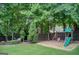 Backyard features a playground, mature trees, a hammock and lush green lawn at 1952 Sugarstone Dr, Lawrenceville, GA 30043