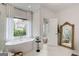 Bright bathroom features a standalone tub, large window, and elegant fixtures, offering a spa-like experience at 1952 Sugarstone Dr, Lawrenceville, GA 30043