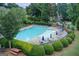 Community pool area with lounge chairs, tables, umbrellas, and landscaped surroundings at 1952 Sugarstone Dr, Lawrenceville, GA 30043