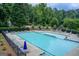 Large community pool featuring lounge chairs, umbrellas and a fenced perimeter at 1952 Sugarstone Dr, Lawrenceville, GA 30043