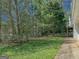 Exterior view of backyard showing mature trees, partial fencing, and the home's siding at 902 Sweetbay Ct, Stockbridge, GA 30281