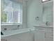 Bright bathroom features a soaking tub, a window, and modern fixtures at 902 Sweetbay Ct, Stockbridge, GA 30281