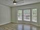 Bright bedroom featuring wood floors, ceiling fan, and bay windows with lovely views at 902 Sweetbay Ct, Stockbridge, GA 30281