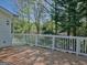 Wooden deck with white railing offering views of surrounding trees and a glimpse of neighborhood rooftops at 902 Sweetbay Ct, Stockbridge, GA 30281