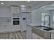 Contemporary kitchen with white cabinetry, modern appliances, and stylish backsplash at 902 Sweetbay Ct, Stockbridge, GA 30281