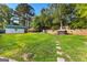Expansive backyard featuring green grass, a shed, a hot tub, and a stone path at 103 Chipstone Ct, Peachtree City, GA 30269