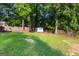 Large backyard with trees, a shed, and grassy areas, perfect for outdoor activities at 103 Chipstone Ct, Peachtree City, GA 30269