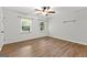 Bright bedroom featuring wood-look floors, white walls, ceiling fan, and natural light through windows at 103 Chipstone Ct, Peachtree City, GA 30269