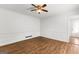 Empty bedroom with hardwood floors, a ceiling fan, and fresh white walls with decorative trim at 103 Chipstone Ct, Peachtree City, GA 30269