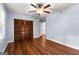 Empty bedroom features hardwood flooring, a ceiling fan, and closet with wood doors at 103 Chipstone Ct, Peachtree City, GA 30269
