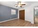 Bedroom features wood-look floors, closet, ceiling fan, a window, and a neutral paint scheme at 103 Chipstone Ct, Peachtree City, GA 30269