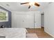 Bright bedroom features a ceiling fan, wood floors, and a closet with modern white doors at 103 Chipstone Ct, Peachtree City, GA 30269