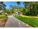 Long driveway leading to a two-story home with a white brick facade and a spacious, manicured lawn at 103 Chipstone Ct, Peachtree City, GA 30269