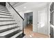 Bright foyer with wooden floors, black and white staircase, and white paneled doors at 103 Chipstone Ct, Peachtree City, GA 30269