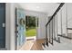 Inviting foyer with light wood floors, open blue door, staircase, and wreath at 103 Chipstone Ct, Peachtree City, GA 30269