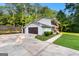 Side view of the home featuring a two-car garage, spacious driveway, and well-maintained landscaping at 103 Chipstone Ct, Peachtree City, GA 30269