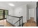 Upstairs hallway with dark-stained wood railing, glass doors, and wood-look floors at 103 Chipstone Ct, Peachtree City, GA 30269
