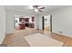 Open living room featuring hardwood floors, a ceiling fan, and an open kitchen with cherry cabinets at 103 Chipstone Ct, Peachtree City, GA 30269