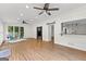 Bright living room with hardwood floors, a ceiling fan, large windows and a door and passthrough to kitchen at 103 Chipstone Ct, Peachtree City, GA 30269