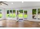 Bright living room with hardwood floors, large windows, and French doors leading to the backyard deck at 103 Chipstone Ct, Peachtree City, GA 30269