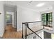 Upstairs hallway with hardwood floors and glass paneled door to balcony at 103 Chipstone Ct, Peachtree City, GA 30269