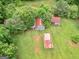 Aerial view of the property with blue and red-roofed sheds surrounded by lush greenery at 778 Leguin Mill Rd, Locust Grove, GA 30248