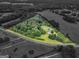 Aerial view highlighting the home's location, surrounded by lush greenery and a well-manicured lawn, in an established setting at 778 Leguin Mill Rd, Locust Grove, GA 30248