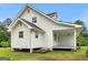 Side view of a home with light gray siding, a gray roof, and a covered porch with wooden steps at 778 Leguin Mill Rd, Locust Grove, GA 30248