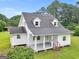 Charming home featuring a covered front porch, gray roof, and light gray siding, surrounded by lush landscaping at 778 Leguin Mill Rd, Locust Grove, GA 30248